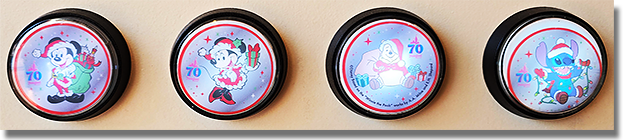 Buttons: Main Street Penny Arcade / Candy Palace - Main Street, Disneyland Park, USA. Button 1: #247 Colorized metallic silver medallion, 70th Logo, Santa Mickey Mouse with stars in the design field, red ring at the medallion rim. Button 2: #248 Colorized metallic silver medallion, 70th Logo, Santa Minnie Mouse with stars in the design field and a red ring at the medallion rim. Button 3: #249 Colorized metallic silver medallion, 70th Logo, Santa Winnie The Pooh with stars in the design field, a copyright notice across the bottom of the image and a red ring at the medallion rim. Button 4: #250 Colorized metallic silver medallion, 70th Logo, Stitch with stars in the design field and a red ring at the medallion rim. Onstage November 4, 2025.