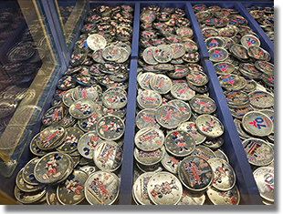 Window:  Candy Palace - Main Street Penny Arcade Colorized Medallions.  Button 1: #303 Happy 250th Mickey Mouse.  June 14, 2026.  Button 2: #304 Happy 250th Minnie Mouse, June 14, 2026.  Button 3: #254 70th Logo, Classic Disneyland Seven Flag Roadside Marquee with stars in the design field. December 25, 2025. Button 4: #252 70th Logo, Walt and Mickey, Partners with stars in the design field. December 25, 2025.